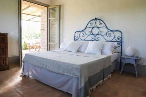 sypialnia z dużym łóżkiem z niebieskim zagłówkiem w obiekcie Villa l'Essiccatoio Deluxe Morcella w mieście Morcella