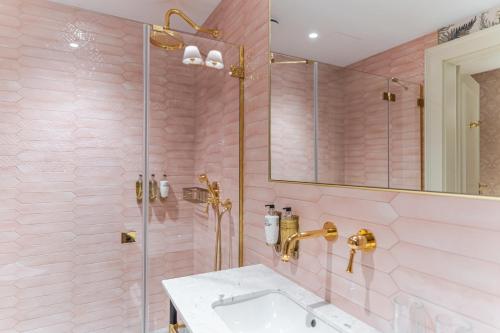 a pink bathroom with a sink and a shower at Hotel Unicus Palace Old Town - Destigo Hotels in Kraków