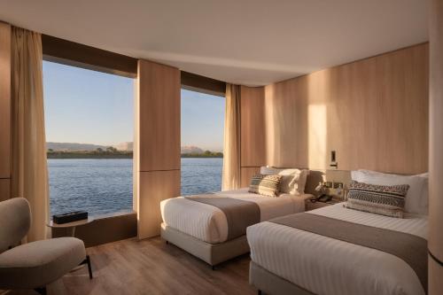 Habitación de hotel con 2 camas y ventana grande. en AQUA THE DAHABEYA - Sundays from Luxor & Fridays from Aswan - Available for Private Bookings en Luxor