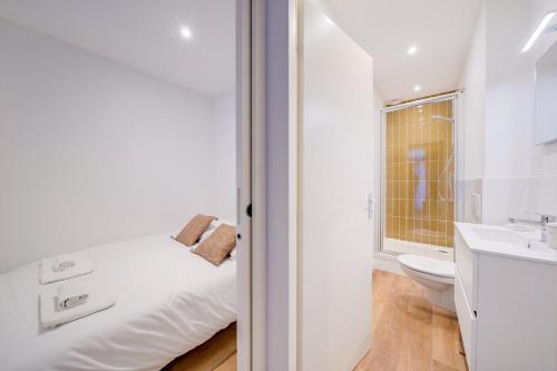 uma casa de banho branca com uma cama e um lavatório em Lovely apartment Bordaux em Bordeaux
