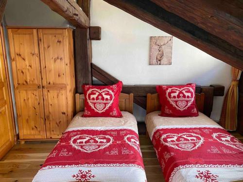2 bedden in een slaapkamer met rode en witte dekens bij 90m2 hypercentre, terrace, next to ski lift in Chamonix-Mont-Blanc
