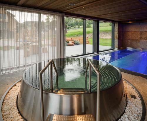 uma casa com uma piscina e uma mesa de vidro em Aldrov Resort em Vítkovice