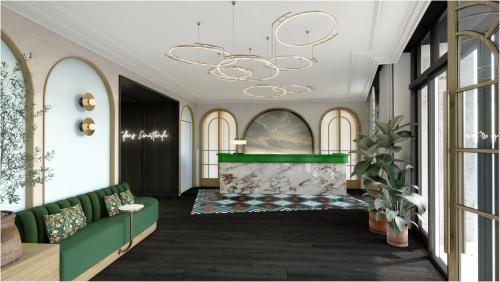 un vestíbulo con un sofá verde y una lámpara de araña en Hotel Grand Coeur Latin, en París