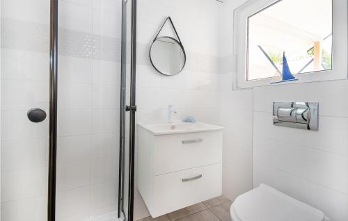 a white bathroom with a sink and a mirror at Stunning Home In Bobolin With Outdoor Swimming Pool in Bobolin