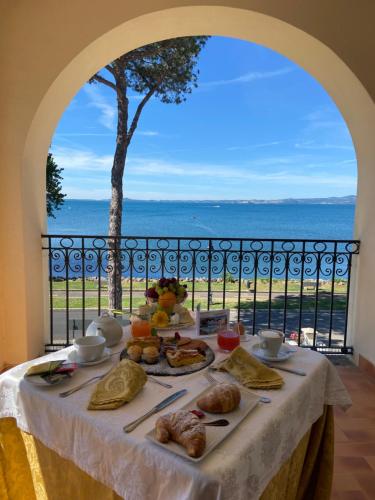 a table with food and a view of the ocean at Hotel Holiday Sul Lago in Bolsena