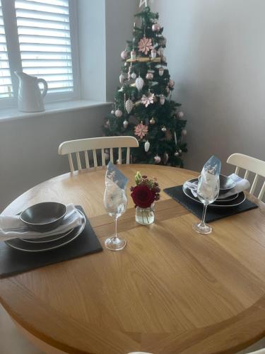 a dining room table with a christmas tree in the background at The Unicorn (Apartments) in Stow on the Wold