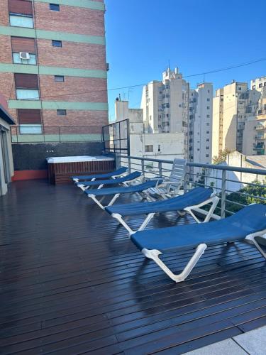 une rangée de chaises longues assises sur un toit dans l'établissement Thames Suite Plaza Italia, à Buenos Aires