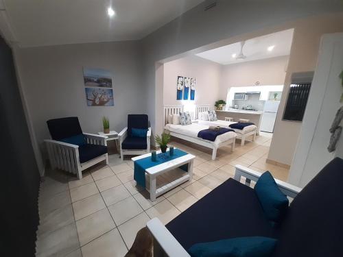 a living room with blue chairs and a couch at CBS Accommodation in Mossel Bay