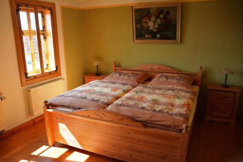 ein Holzbett in einem Schlafzimmer mit Fenster in der Unterkunft Ferienhaus Rentsch in Rudolstadt