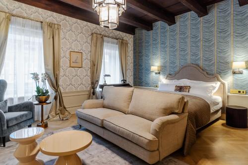 uma sala de estar com uma cama e um sofá em Hotel Unicus Palace Old Town em Cracóvia