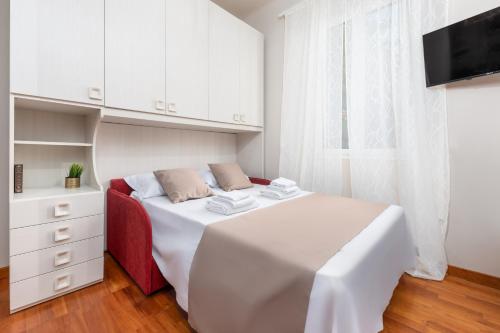 ミラノにあるCasa da Suite Arcoの白いベッドルーム(ベッド1台、テレビ付)