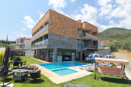 an apartment with a swimming pool and a building at Ornella Butik Otel in Edremit
