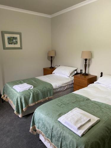 Habitación de hotel con 2 camas con sábanas verdes en Welltrees Apartments 14 Dailly Road Maybole, en Maybole