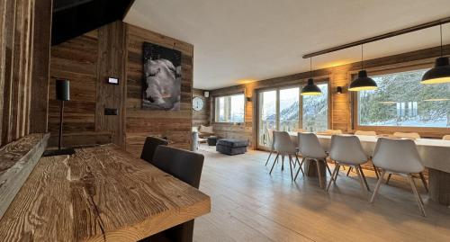 ein Esszimmer mit einem Holztisch und Stühlen in der Unterkunft Paradis Perdu SKI IN & QUIET chalet 14 personnes in Les Collons