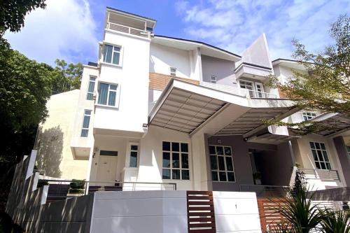 a white house with a lot of windows at Shamrock Breeze Villa: Coastal Haven for 29 Guests in Batu Ferringhi
