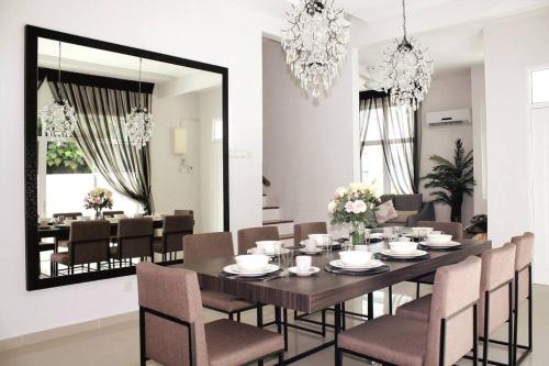 a dining room with a table and chairs and a mirror at Shamrock Breeze Villa: Coastal Haven for 29 Guests in Batu Ferringhi