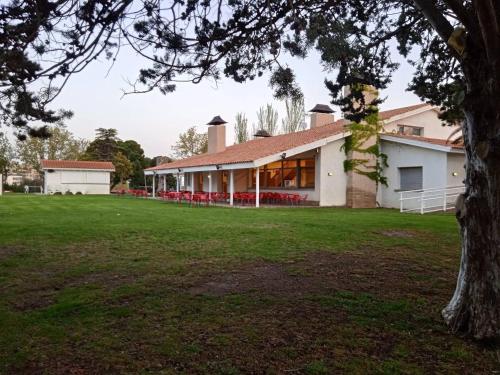 a house with a green lawn in front of it at Albergue Zaragoza Camping in Zaragoza