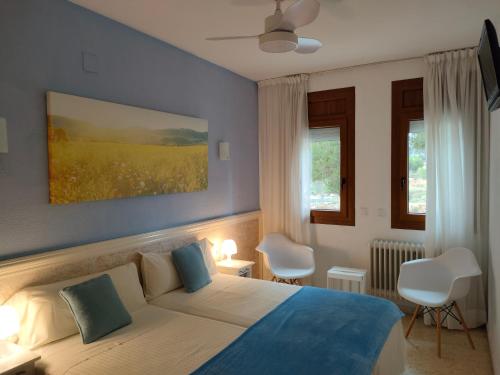 a bedroom with a bed with blue walls and windows at Hostal Los Pinares in Lloret de Mar