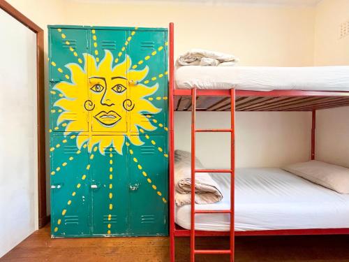 a door with a sun painted on it in a room with bunk beds at Long Street Backpackers in Cape Town