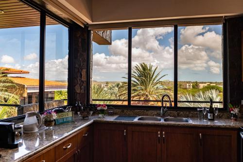 a kitchen with large windows with a view of the desert at Vientos del Caribe Club & Hotel in El Yaque