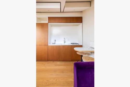 a kitchen with wooden cabinets and a purple couch at Luxury Mansard Villa Borghese in Rome