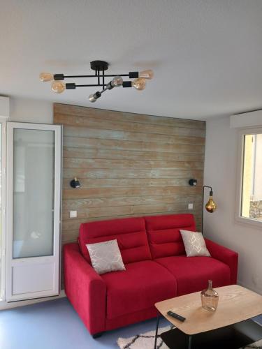 a living room with a red couch and a table at La Campana 107 in Bielle