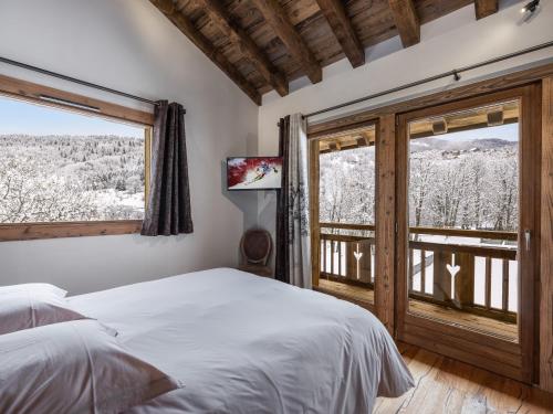 una camera da letto con un letto e una grande finestra di Le Cheval Blanc et Le Loup Blanc, jacuzzi, hammam, skis aux pieds a Méribel