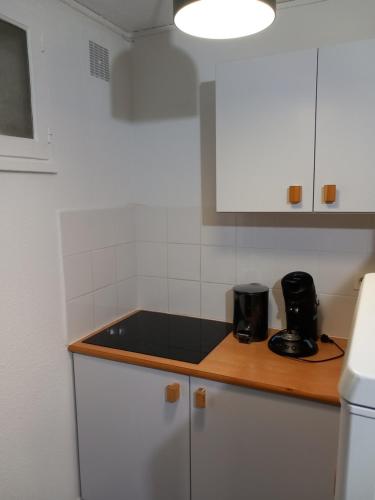a kitchen with white cabinets and a black counter top at La Campana 107 in Bielle