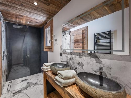 un bagno con due lavandini su un bancone in legno di Le Cheval Blanc et Le Loup Blanc, jacuzzi, hammam, skis aux pieds a Méribel