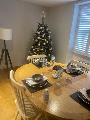 a wooden table with a christmas tree in a room at The Unicorn (Apartments) in Stow on the Wold