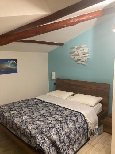 - une chambre avec un lit et un mur bleu dans l'établissement Appartamento Sentiero Azzurro 2, à La Spezia