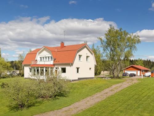 Holiday Home Mustijoenranta by Interhome في Nummistenkylä: بيت ابيض بسقف برتقالي على ارض خضراء