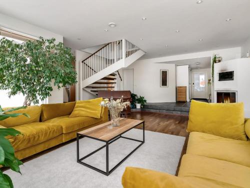 uma sala de estar com um sofá amarelo e uma mesa em Holiday Home Mustijoenranta by Interhome em Nummistenkylä