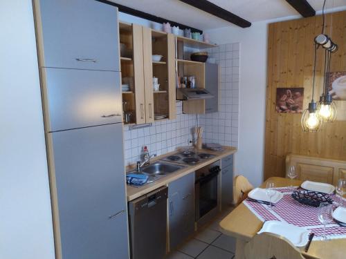 een keuken met een witte koelkast en een tafel bij Apartment Am Hohen Bogen-35 by Interhome in Arrach