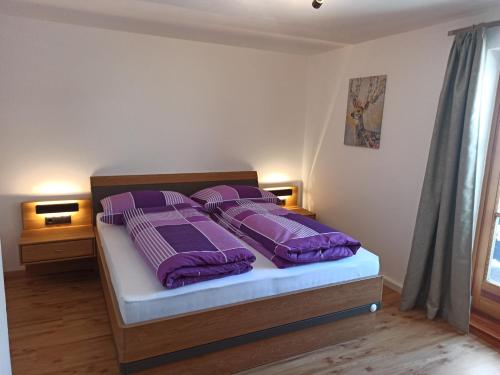 a bedroom with a bed with purple sheets and pillows at Stefflgut Appartements in Maishofen