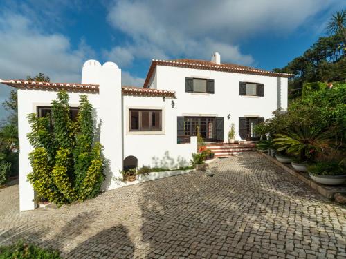 a white house with a cobblestone driveway at Holiday Home Oliveiras House - C in Sintra