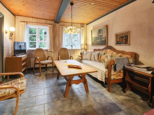 uma sala de estar com um sofá, uma mesa e um piano em Holiday Home Marinka - 8km from the sea in Western Jutland by Interhome em Højer