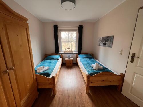 2 camas en una habitación pequeña con ventana en Ferienhaus Bergblick - mit Sauna und Dampfbad und Yacuzzi, en Sehma