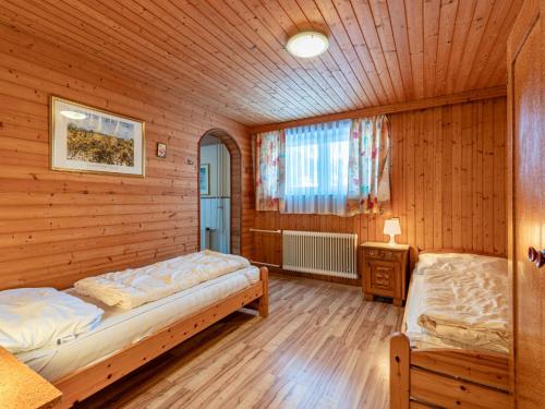 1 dormitorio con 2 camas en una habitación de madera en Holiday Home Pilz II - SLD510 by Interhome, en Rohrmoos-Untertal