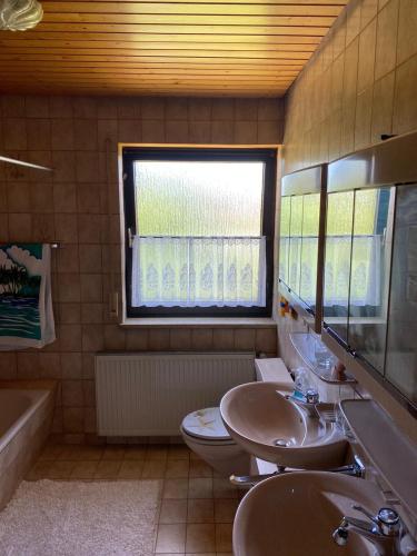 a bathroom with two sinks and a toilet and a window at Alex in Schwäbisch Gmünd