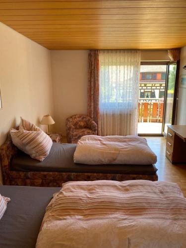 ein Hotelzimmer mit 2 Betten und einem Stuhl in der Unterkunft Alex in Schwäbisch Gmünd