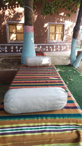 a bed with two pillows sitting on top of a rug at Bendre's Farm Stay-Neral in Neral