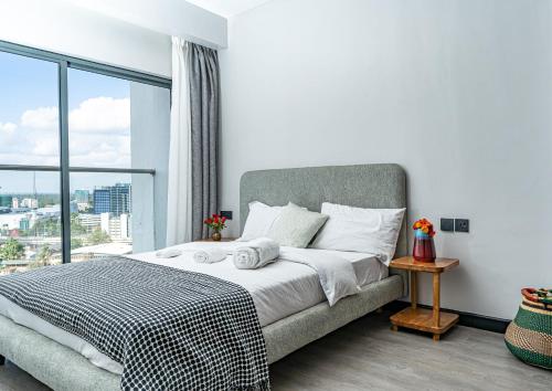 ナイロビにあるEscada Studio & 2-bedroom, Rooftop Swimming Pool, Gym, Workspace, Wonderiss Homes Westland Livingのベッドと大きな窓のある寝室