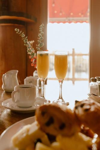 a table with two glasses of orange juice and a plate of food at Auberge du Lac Taureau et Condos in Saint-Michel-des-Saints