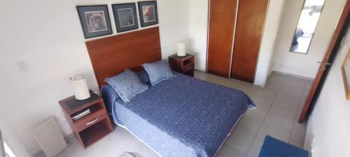 1 dormitorio con cama azul y cabecero de madera en FMSHOUSEdos en Villa Santa Cruz del Lago
