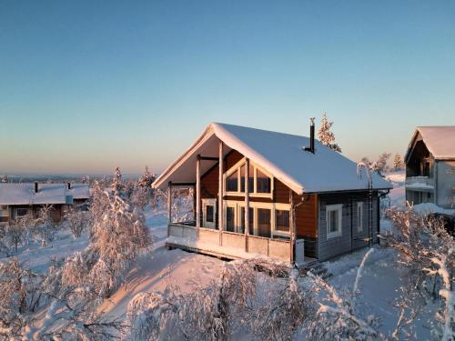 a house covered in snow in a field at Holiday Home Napakettu by Interhome in Saariselka