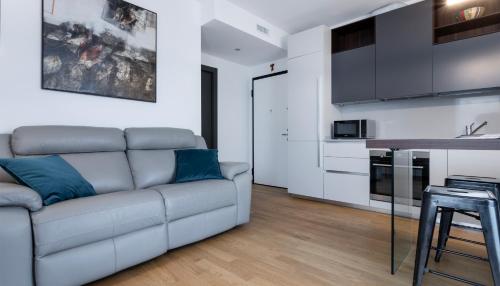 a living room with a couch and a kitchen at Italianway - Albani 20 in Milan