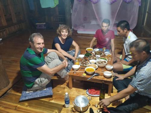 a group of people sitting around a table eating food at Dao homestay Vũ Linh in Yên Bình