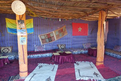 a blue room with tables and flags on the wall at Sahara Berber Camp - Mhamid Discovery Camp in Mhamid el Rhozlane