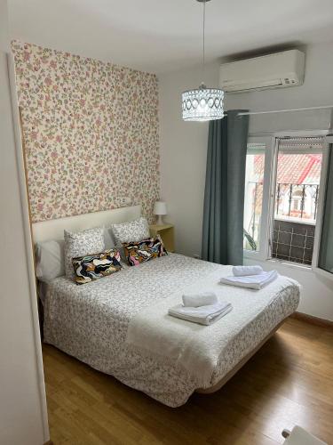 Hostal Flat55Madrid في مدريد: غرفة نوم مع سرير بجدار نمط